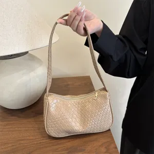Woven shoulder bag detail, stylish beige underarm handbag showcasing intricate leather texture.