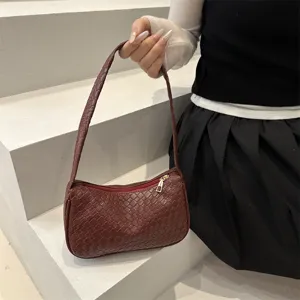 Woven shoulder bag scene display, detailed view of dark red leather intrecciato handbag.