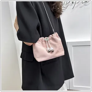 Pink drawstring bucket bag for women, stylish shoulder crossbody bag with chain strap and pearls.