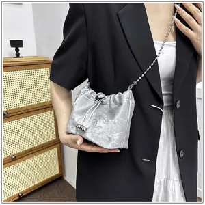 Close-up detail of a chic silver metallic bucket bag featuring an elegant chain strap style.