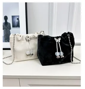 Elegant velvet bucket bag with chain strap and butterfly charm, perfect for daily wear.