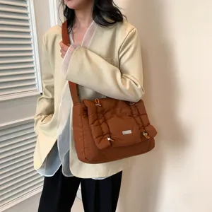 Bruine gewatteerde schoudertas voor dames, stijlvolle gewatteerde crossbodytas met klep en metaal.
