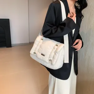 Gedetailleerd overzicht van de witte gewatteerde puffer crossbody tas met brede riem en zacht design.