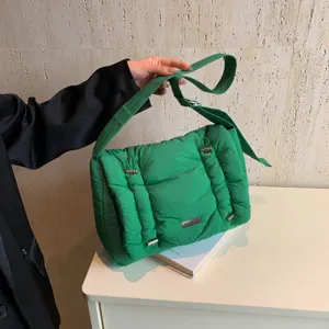 Gedetailleerd overzicht van de trendy groene gewatteerde schoudertas met gespen.