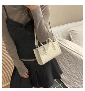 Chic minimalist white shoulder bag for women, versatile daily messenger and retro handbag.
