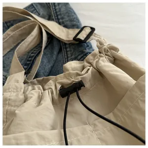 Beige lässige Umhängetasche mit Kordelzug und verstellbaren Trägern für den Alltag.
