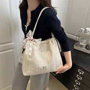 Detail shot of the stylish woven straw tote bag with elegant lace ribbon bow, large capacity.