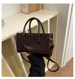 Stylish brown leather handbag for women, casual crossbody bag with top handle and strap.