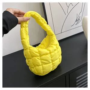 Bright yellow quilted cloud puffer handbag detail, cozy mini underarm bag texture.