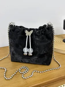 Black velvet bucket bag with silver ball chain strap and butterfly drawstring closure, main view.
