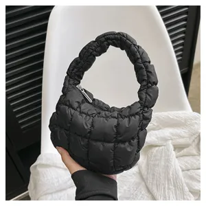 Close-up detail of a black quilted cloud handbag featuring stylish pleated handles and texture.