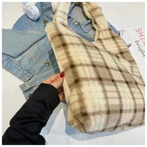 Close-up detail of the soft fuzzy plaid tote bag paired with stylish denim jacket and props.