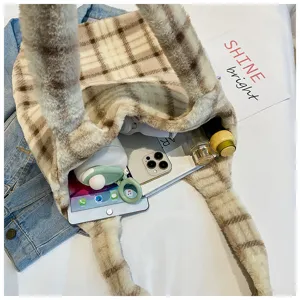 Detailed view of fluffy plaid tote bag filled with daily items on white clean background.