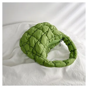 Green quilted puffer cloud bag detail, trendy mini underarm handbag with soft padded grid texture.