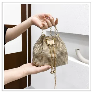 Vue de détail du sac seau étincelant en strass avec une chaîne dorée élégante et un lien coulissant.