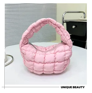 Pink quilted puffer cloud bag detail shot, showing soft texture and metal zipper closure.