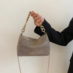 Close-up detail of luxury sparkling rhinestone evening bag with chunky gold chain handle.