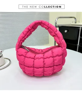 Close-up view of the vibrant pink quilted cloud bag, showcasing soft puffy texture and zipper.