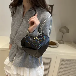 Black patent leather heart shaped crossbody bag with metal chain strap, chic niche design.