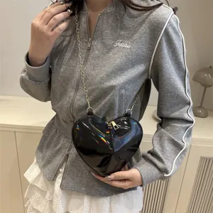 Black patent leather heart-shaped crossbody bag with gold chain strap for stylish daily wear.