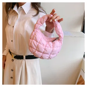 Close-up detail of trendy pink quilted cloud bag, stylish mini handbag for women.