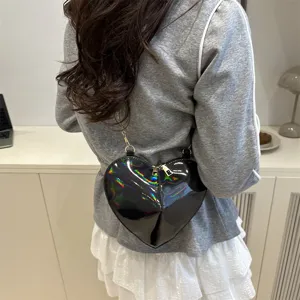 Glossy black heart-shaped crossbody bag detail showcasing the patent leather texture.