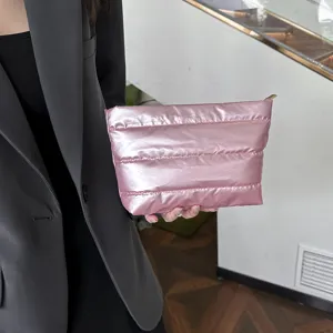 Chic pink padded clutch bag for women, stylish shiny cosmetic pouch with quilted design.