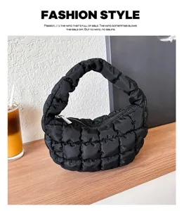 Detailed shot of black quilted puffer cloud handbag, featuring soft padded texture and zipper.