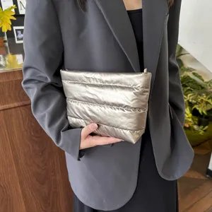Metallic silver quilted clutch bag detail shot, handheld lifestyle fashion accessory view