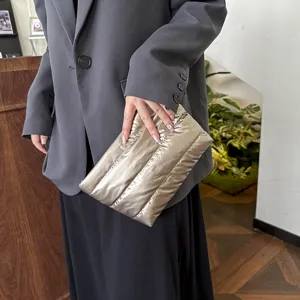 Detailed view of the trendy metallic quilted clutch bag, soft oversized puffer design for women.