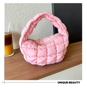 Pink quilted cloud bag detail shot, stylish dumpling handbag with zipper closure and soft texture.