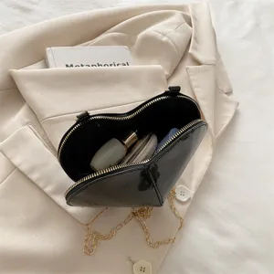 Trendy black patent leather heart shaped crossbody bag for women, chic mini shoulder bag with chain.