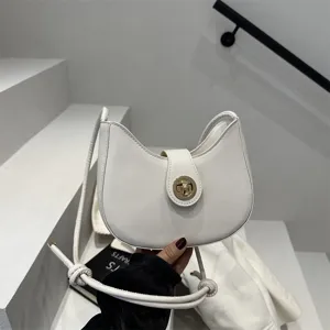 Detail view of the elegant white crescent shoulder bag, showcasing smooth lines and gold lock.