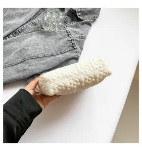 White floral quilted cosmetic bag detail shot, soft padded clutch for daily travel use.