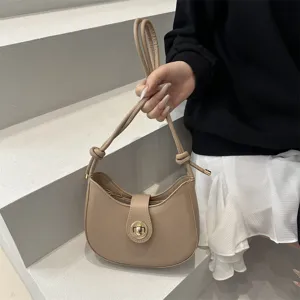 Detailed view of minimalist beige underarm hobo bag featuring elegant turn-lock closure.