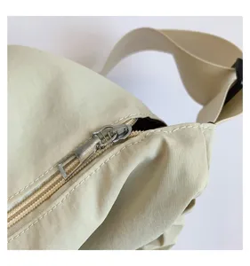 Detailansicht der lässigen Nylon-Umhängetasche mit Reißverschluss, beige, minimalistisch.