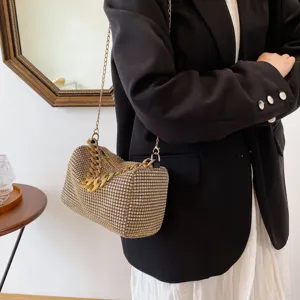 Close-up detail of a glamorous rhinestone evening shoulder bag with a luxurious chunky gold chain.