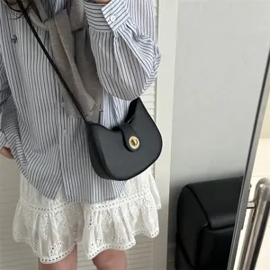 Minimalist black underarm shoulder bag for women, chic dumpling design with gold lock detail.