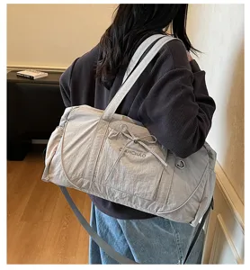 Detailed shot of casual lightweight gym duffel bag with bow design, practical travel shoulder bag.