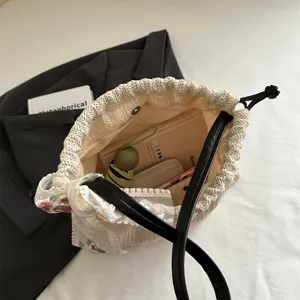 Stylish women's woven straw tote bag with black handles and lace ribbon for autumn.