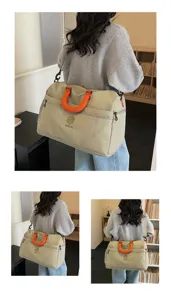 Travel duffel bag detail, large capacity luggage bag with orange handles and shoulder strap.