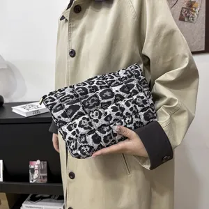 Detailopname van de zwart-witte luipaardprint nylon gewatteerde handtas voor dames casual.