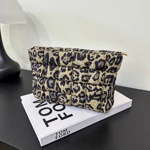 Gewatteerd nylon cosmetisch tasje met luipaardprint en gouden ritssluiting details.