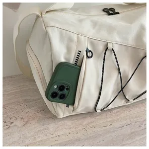 Detail shot of a beige travel duffel bag with side pocket and elastic cords, large capacity gym bag