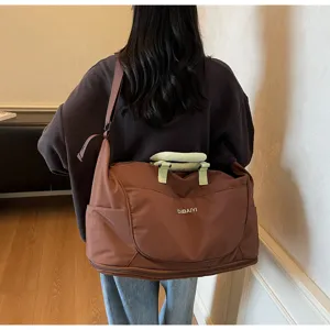 Close-up detail showing the large capacity expandable travel duffel bag with dual green handles.