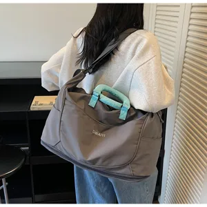 Spacious expandable travel duffel bag in gray with light blue handle wrap for gym and business trip.
