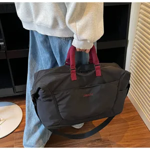 Detailed view of the large capacity travel duffel bag with shoulder strap and durable handles.