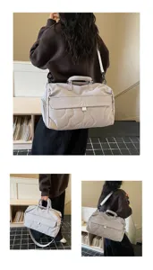 Quilted travel duffle bag with top handle and shoulder strap for gym, travel, and daily use.