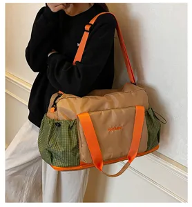 Detail shot of large capacity travel duffel bag with wet dry separation and green side pockets.