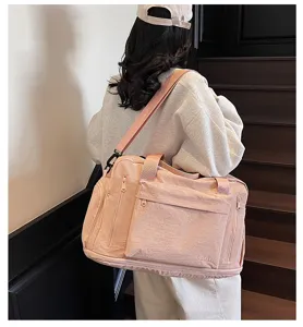 Pink large capacity travel duffel bag with front zipper pocket and adjustable shoulder strap.